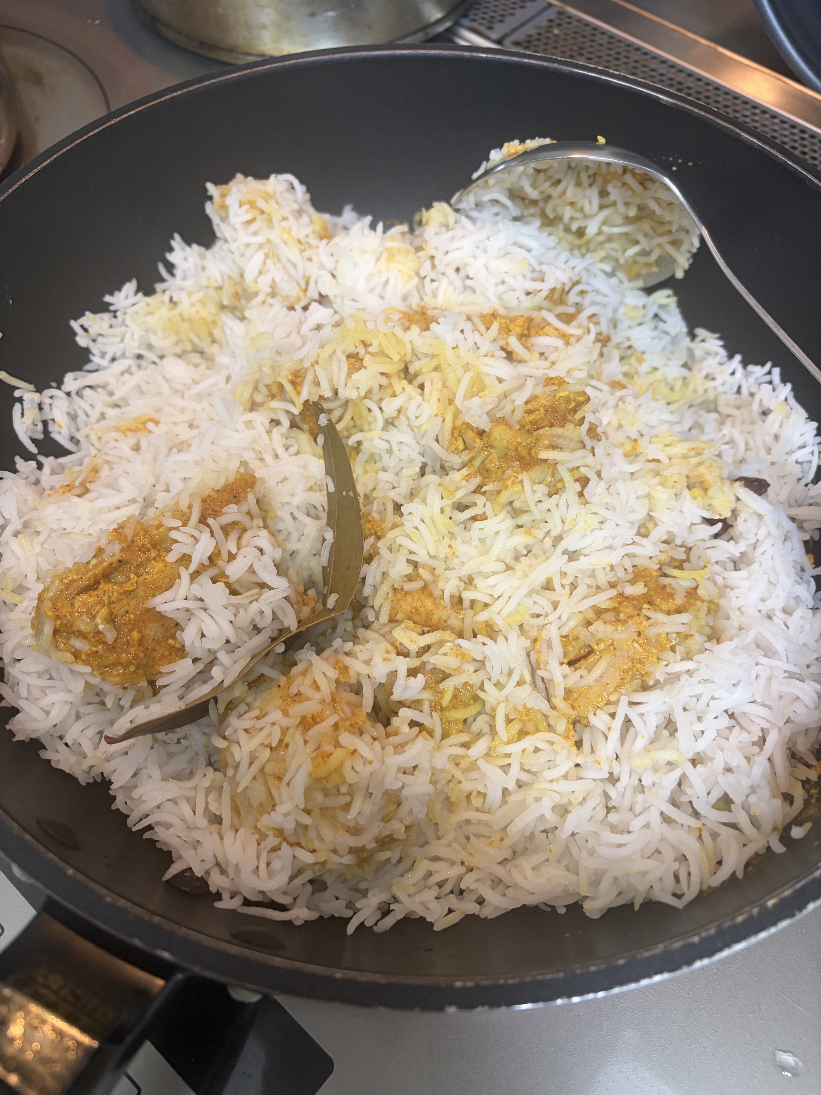 フライパンで蒸しているチキンビリヤニ