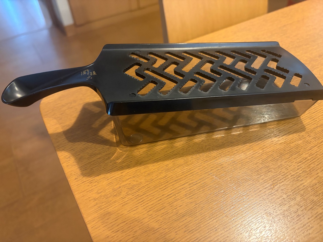 受け皿にのせた貝印のおろし器を横から見た様子
