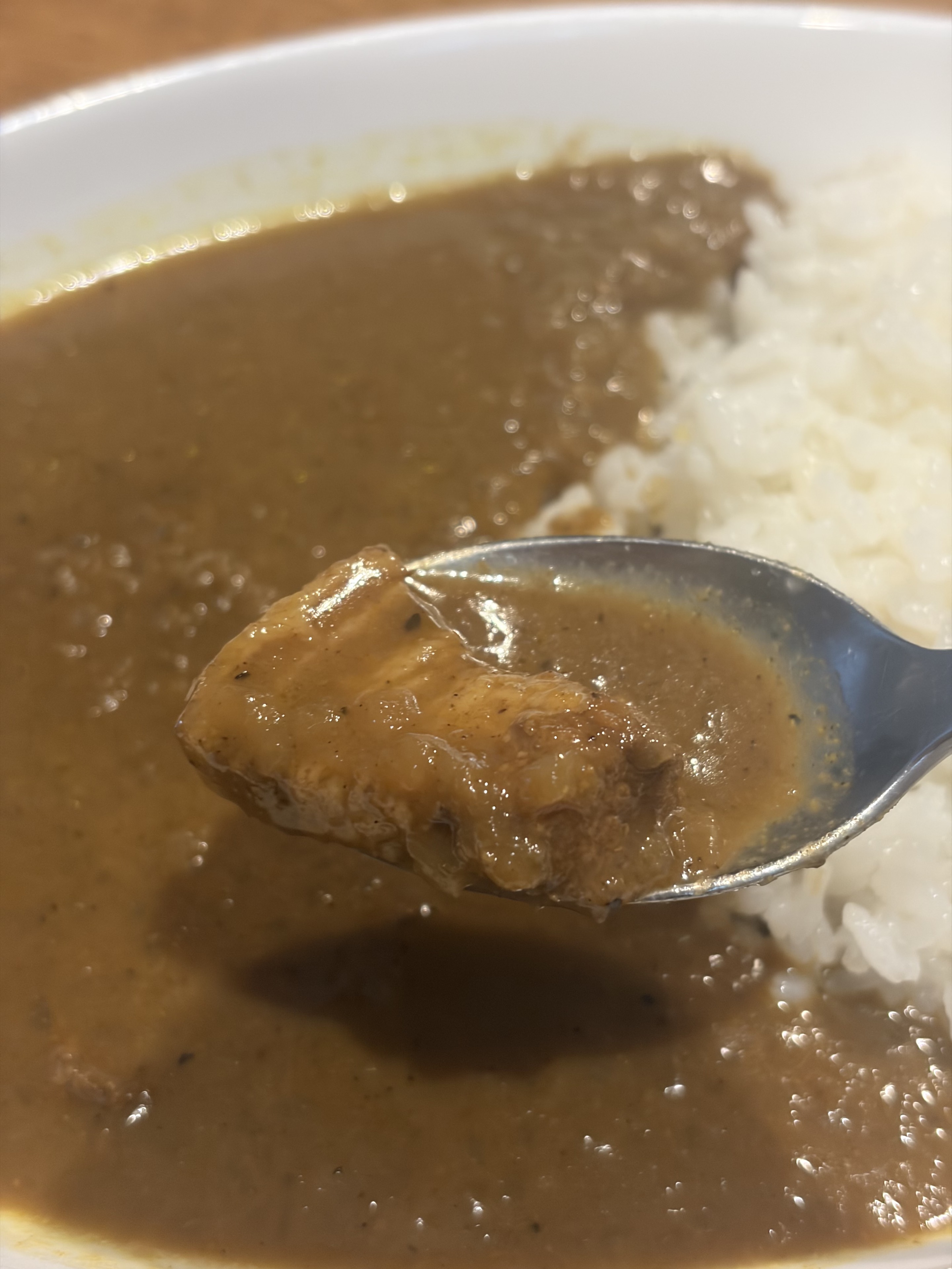 スプーンにのせた無印の豚肉とタマリンドのスパイシーカレーの豚肉
