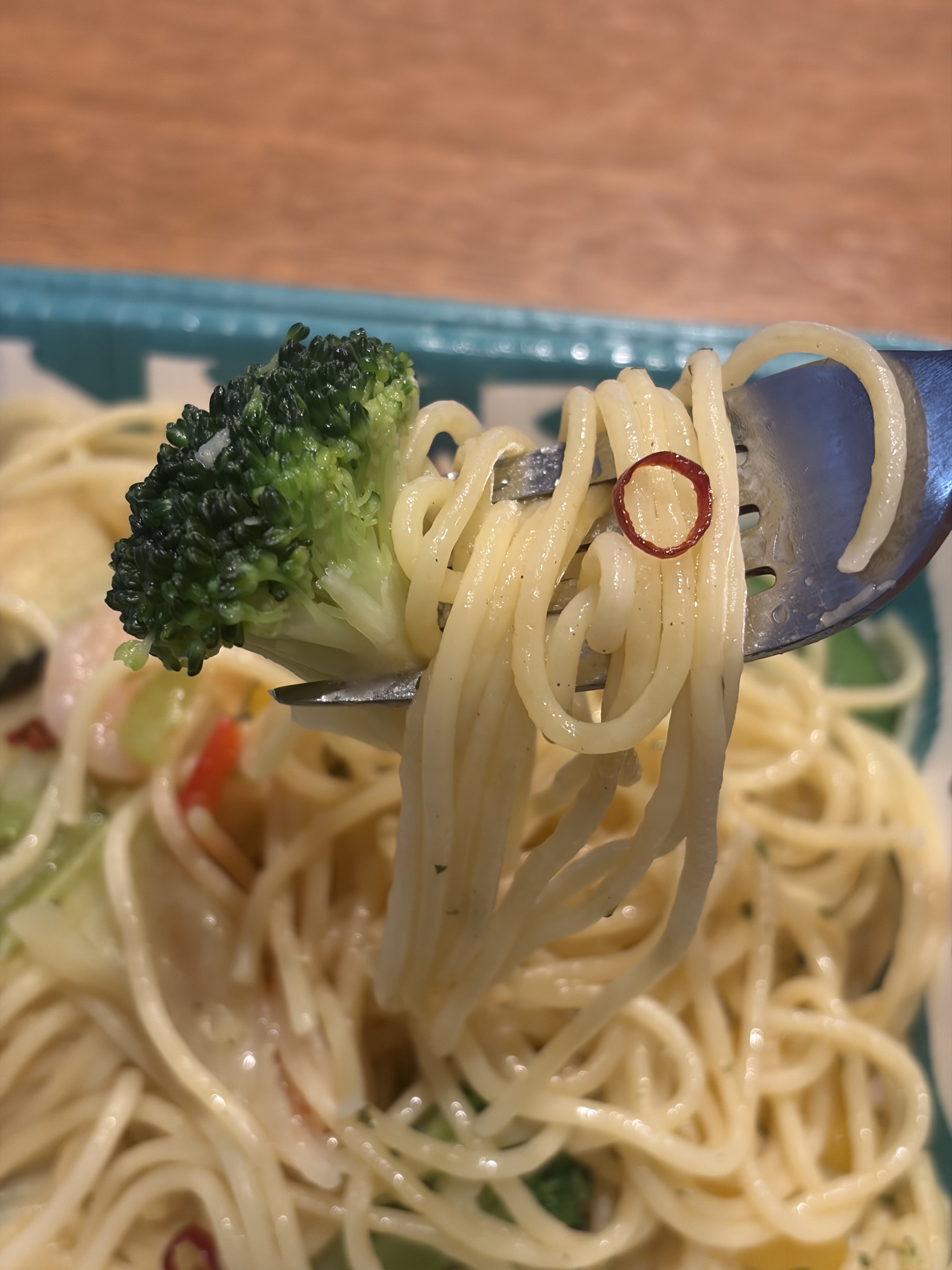 フォークで持ち上げたペペロンチーノの麺とブロッコリー